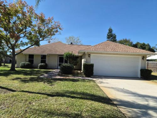 een huis met een oprit en een garage bij The Launch Pad in Titusville