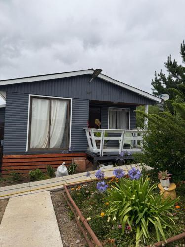 uma casa azul com uma varanda branca e um jardim em Cabañas a 7 minutos centro Papudo 