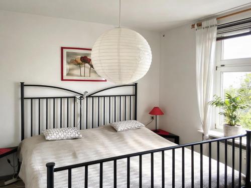 une chambre avec un lit avec une grande lampe blanche dans l'établissement Villa Charlotte, à Bad Suderode