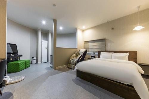 a bedroom with a bed and a desk and a tv at 부띠끄 이틀호텔 in Cheongju
