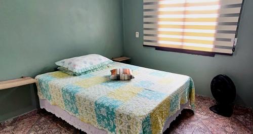 a bedroom with a bed with a quilt on it at Casa de Benê in Tramandaí