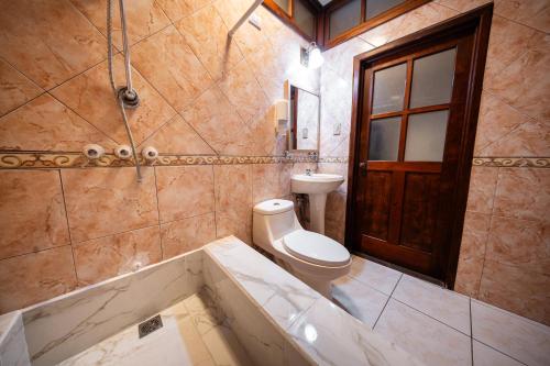 un baño con inodoro y bañera en Los Faroles Zona 3, en Cobán