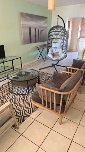 a living room with couches and chairs and tables at Richmond Hill Guesthouse- Serviced Condo in Gqeberha
