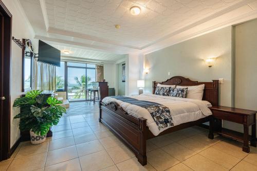 ハコにあるParadise Jaco Beach Frontの大きなベッドとテーブルのある寝室