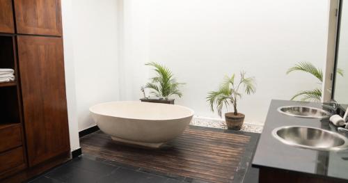 a bathroom with a bath tub and two sinks at Villa Nata Umalas in Seminyak