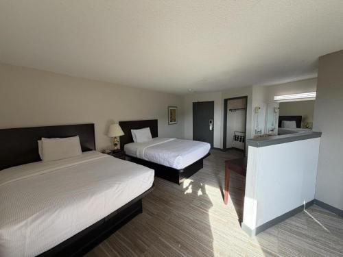 een hotelkamer met twee bedden en een keuken bij University Inn & Suites in Stevens Point