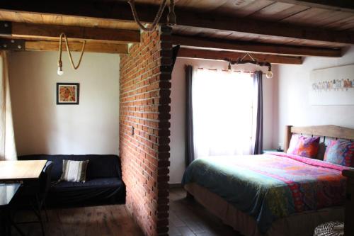 a bedroom with a bed and a brick wall at Acogedora cabaña cerca del desierto de los leones y CC santa Fe in Mexico City