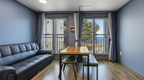 a living room with a couch and a table at Samcheok Lamer Pension in Samcheok