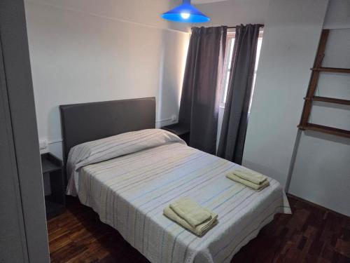 a bedroom with a bed with two towels on it at Amplio Departamento Céntrico in Barraquero