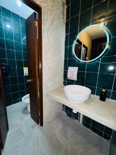 a bathroom with a sink and a mirror and a toilet at Leveli Coliving & Hostel Oaxaca in Oaxaca City