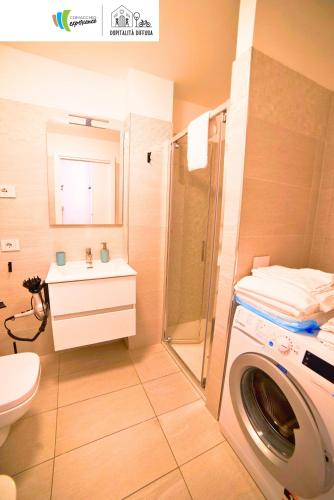 a bathroom with a washing machine and a sink at Comacchio Experience - Ospitalità Diffusa in Lido di Pomposa
