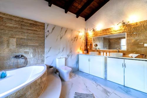 un bagno con vasca, WC e lavandino di Villa Claire 10-Acre Private Estate with Pool near Corfu Old Town a Gastouri