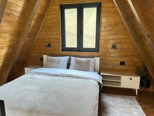 a bedroom with a bed in a wooden cabin at Terra Ruj in Mokra Gora