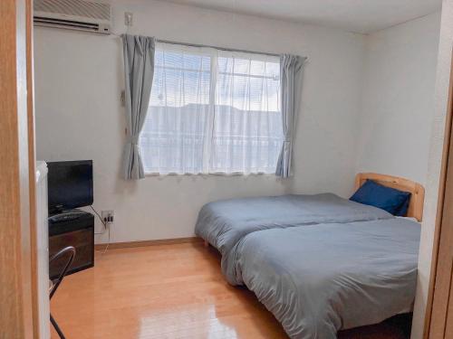 Ένα ή περισσότερα κρεβάτια σε δωμάτιο στο ゲストハウスレポーレ山大前