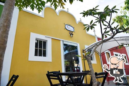 a yellow building with a table in front of it at Refúgio com quintal gramado in Parnamirim