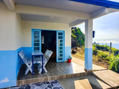 ein kleines Haus mit einem Tisch und Stühlen auf einer Veranda in der Unterkunft Campo Azul Casa Campestre en Buenavista Quindío in Buenavista