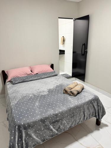 a bedroom with a bed with a gray comforter at Suítes da Orla Hospedagens in Arraial do Cabo