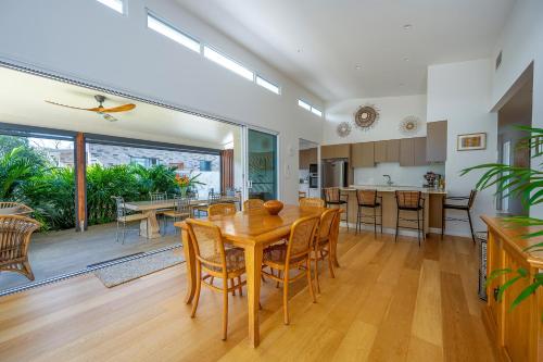 a kitchen and dining room with a wooden table and chairs at Brunswick Lux - Close to Creek & Beach in Brunswick Heads