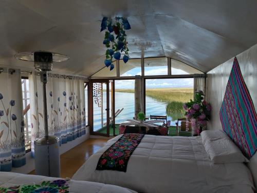 Mistica Titicaca Perú lodge في بونو: غرفة نوم بسرير وإطلالة على الماء