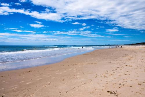 a beach with people walking on the sand and the ocean at Brunswick Lux - Close to Creek & Beach in Brunswick Heads