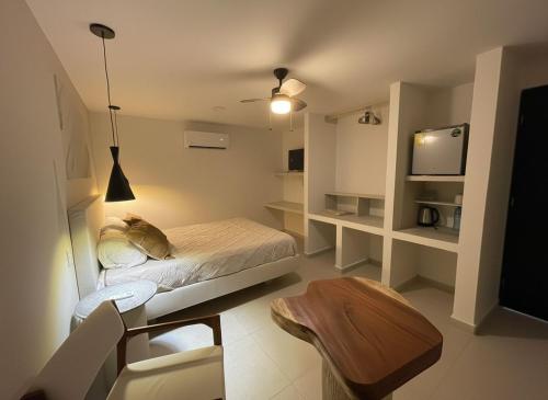 Un dormitorio con una cama, una mesa y un televisor. en Casa Buenaventura, en Mérida