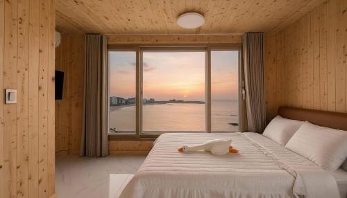 Goseong Leumeleu63 Pension في محافظة غوسونغ: سرير عليه بطة لعبة أمام نافذة