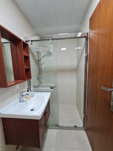 un bagno con doccia e lavandino bianco di Upper Room Megatower III a Baguio