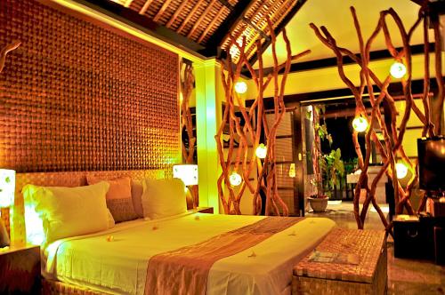 a bedroom with a bed in a room with lights at The Zala Villa in Canggu