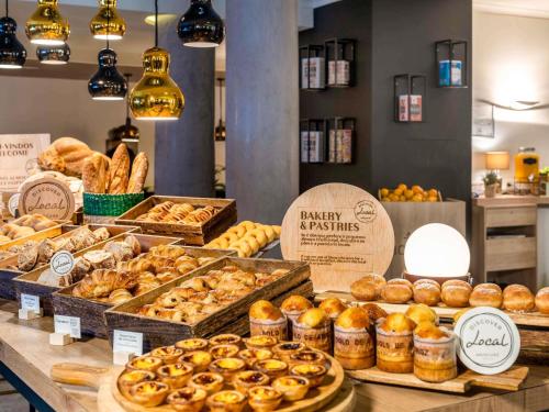 una panadería con muchos tipos diferentes de pasteles en un mostrador en Mercure Porto Centro Santa Catarina, en Oporto