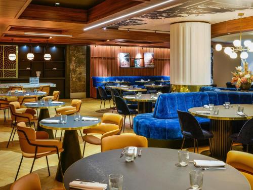a dining room with tables and blue chairs at Mercure Lyon Centre Saxe Lafayette in Lyon
