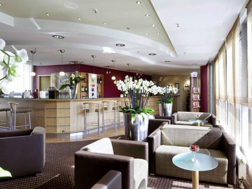 eine Lobby mit Sofas und eine Bar in einem Gebäude in der Unterkunft Mercure Hotel Dortmund City in Dortmund