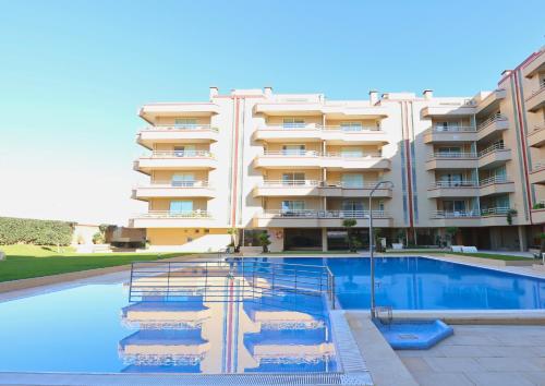 a building with a swimming pool in front of a building at Barramares Pool & Beach in Ovar