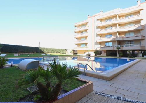 a swimming pool in front of a large building at Barramares Pool & Beach in Ovar