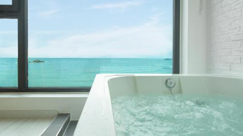 una bañera con vista al mar en Goseong Littlesquare Oceanview Pension, en Goseong