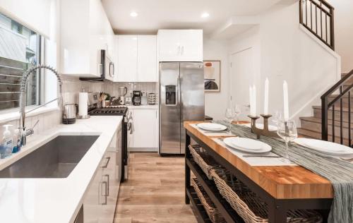 a kitchen with white cabinets and a wooden counter top at Brand New 3B2B Designer Home near SeaTac in Seattle