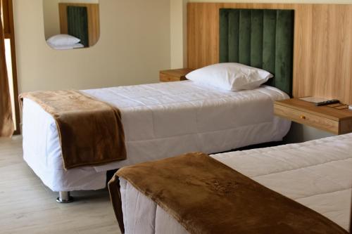 a hotel room with two beds and a table at Phuyu Hotel in Mendoza