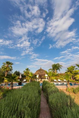 a view of a resort with a pool and palm trees at Ksar Salha in Marrakech