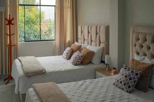 een slaapkamer met twee bedden en een raam bij Hotel Shumaq Yungay in Yungay