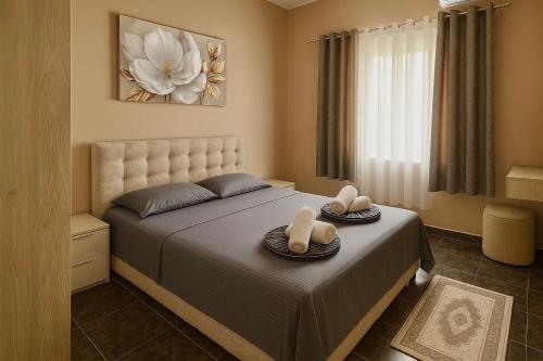 a bedroom with a bed with two towels on it at Midtown Cozy Apartment in Tirana