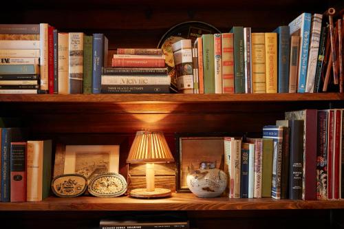 a book shelf with books and a lamp on it at Greydon House in Nantucket