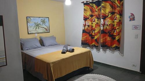 un dormitorio con una cama y un cuadro en la pared en Pousada Costa Verde Tabatinga, en Ubatuba