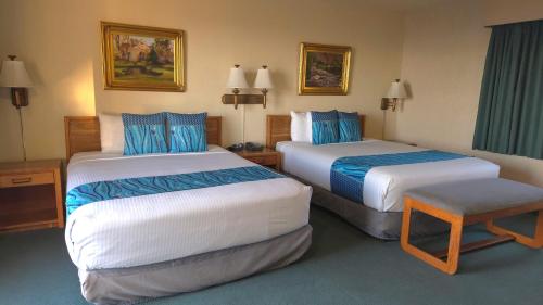 a hotel room with two beds with blue and white at Cabrillo Inn at the Beach in Santa Barbara