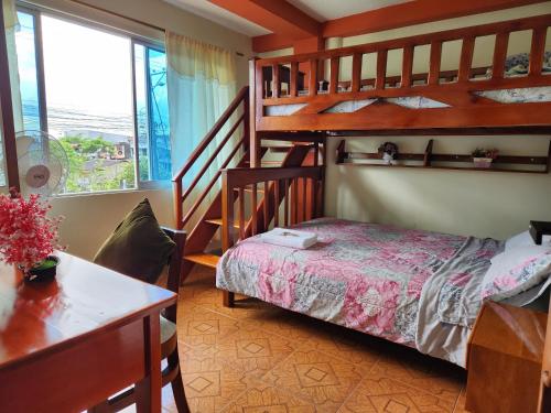 プヨにあるDepartamento Amazonia Ecuadorのベッドルーム1室(二段ベッド、デスク、ベッド1台付)