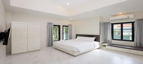 Nua Tone Pool Villa I Mountain View I Bangtao Beach في Ban Thalat Choeng Thale: غرفة نوم بيضاء مع سرير أبيض ونوافذ