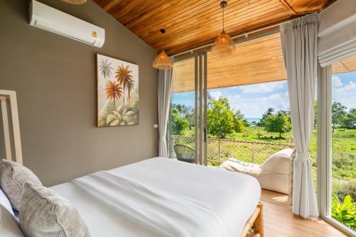 Villa Dana - 2BR Sea View and 1 Studio Room في Hua Thanon Beach: غرفة نوم بها سرير ونافذة كبيرة