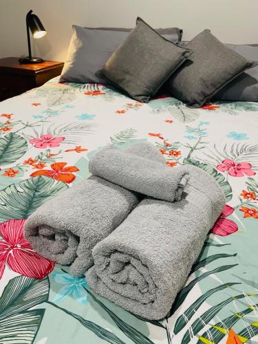 a pile of towels sitting on top of a bed at Bunbury Glen Iris Retreat D in Glen Iris