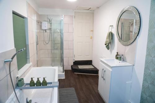 a bathroom with a shower and a sink and a mirror at Long Eaton Cosy Homestay Close to Town & Station in Long Eaton