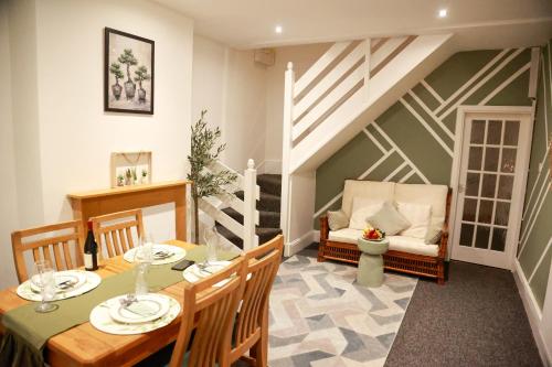 a dining room with a table and a couch at Long Eaton Cosy Homestay Close to Town & Station in Long Eaton