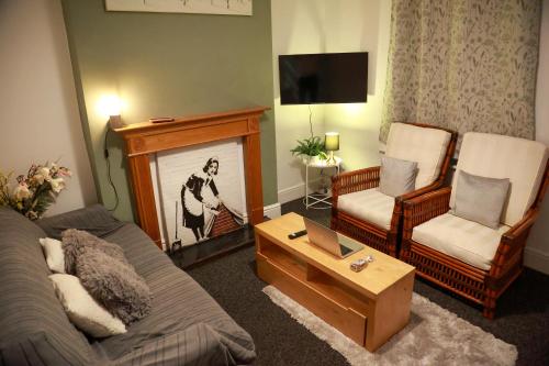 a living room with a couch and a fireplace at Long Eaton Cosy Homestay Close to Town & Station in Long Eaton