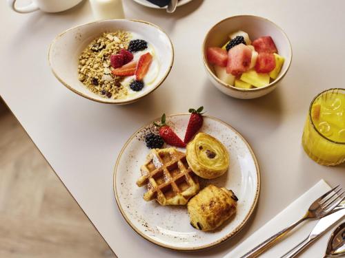 una mesa cubierta con platos de comida y tazones de fruta en Novotel Bristol Centre, en Bristol